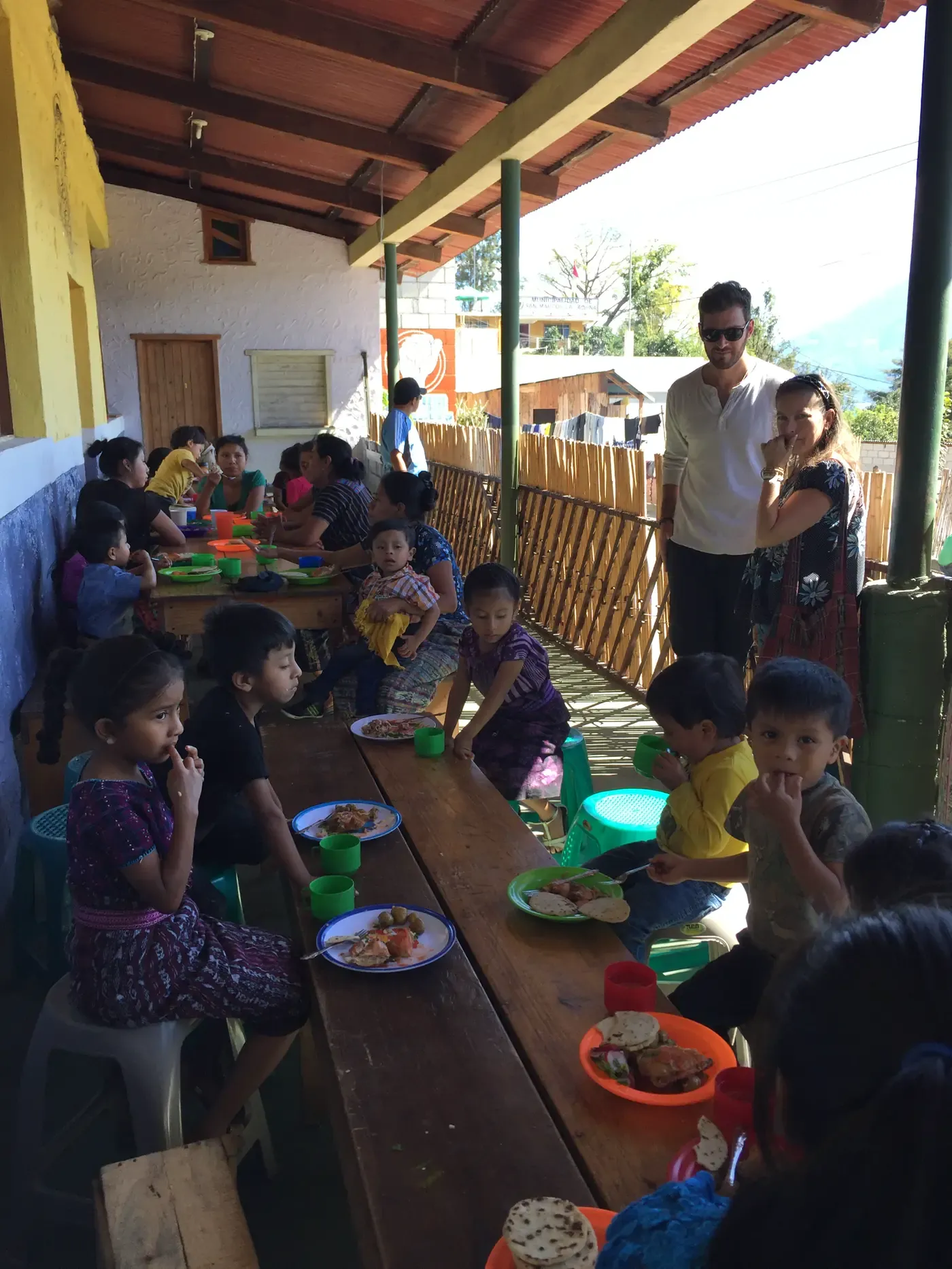 Children eating lunch at long tables in a community kitchen