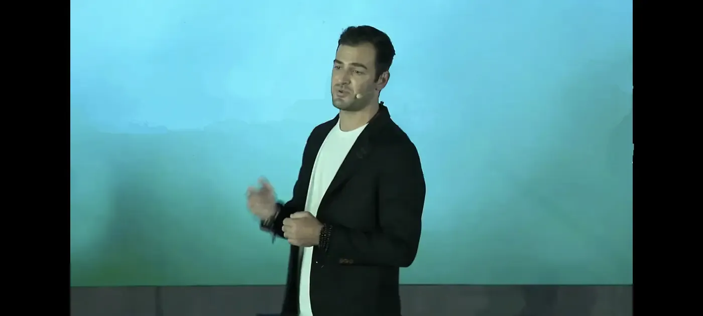 Grant Kendzior mid-talk against a lit backdrop